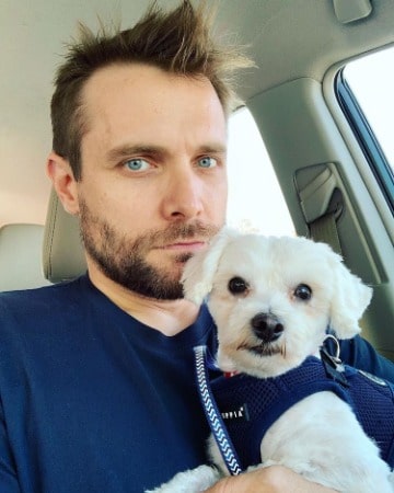 Picture of Neil Hopkins in a car with his pet dog